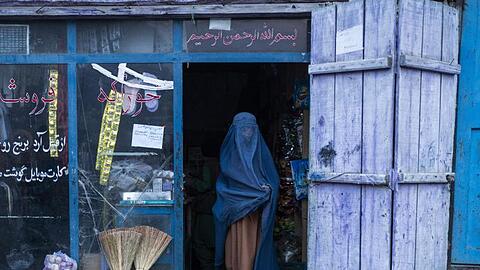 Eine afghanische Frau, die eine Burka trägt, verlässt einen kleinen Laden in Kabul (Archivbild).