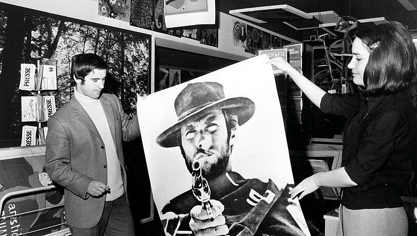 Der Bomber und der Ballermann: Bayern-Torjäger Gerd Müller interessiert sich in den 60er Jahren für ein Poster mit Westernheld Clint Eastwood. Der Bomber und der Ballermann: Bayern-Torjäger Gerd Müller interessiert sich in den 60er Jahren für ein Poster mit Westernheld Clint Eastwood.
