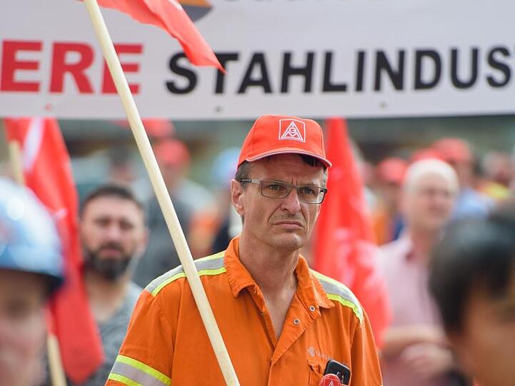 Mitarbeiter von Saarstahl stehen während einer Kundgebung auf dem Gelände von Saarstahl in Völklingen (Saarland).