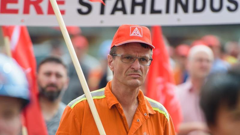 Mitarbeiter von Saarstahl stehen während einer Kundgebung auf dem Gelände von Saarstahl in Völklingen (Saarland).