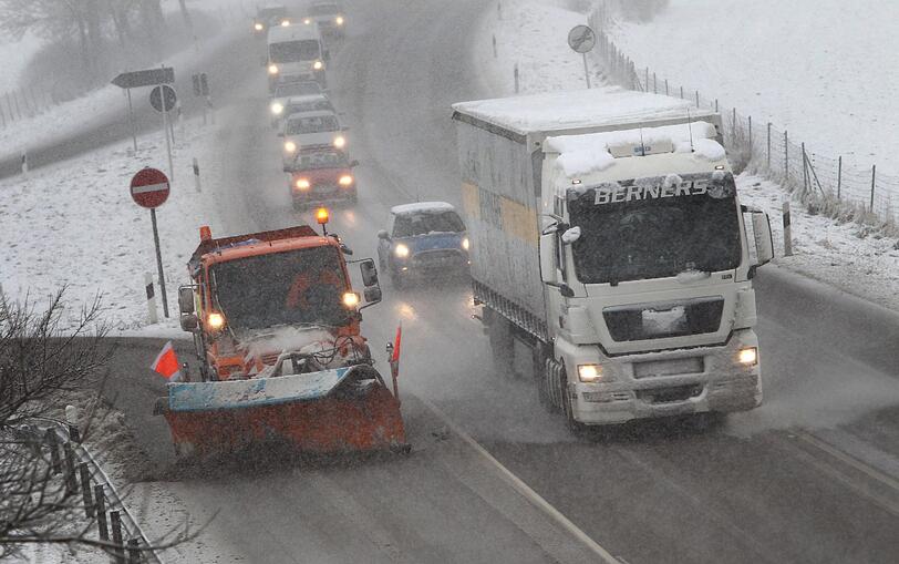 Ein Räumfahrzeug kehrt den Schnee von der Bundesstraße 12 bei Geisenried (Bayern).