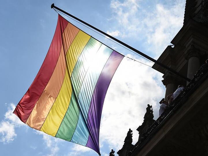 Eine Regenbogenfahne weht im Wind. Foto: Marcus Brandt/dpa