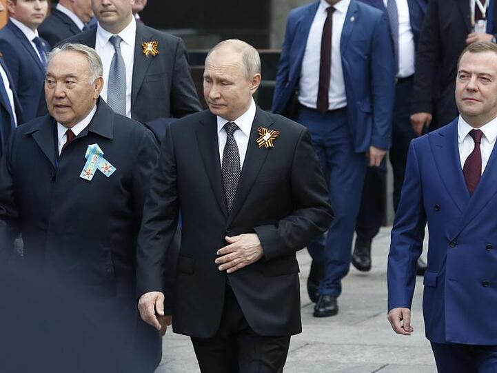 Der kasachische Ex-Präsident Nursultan Nasarbajew (v.l.), Wladimir Putin und Russlands Ministerpräsident Dmitri Medwedew kommen zur Militärparade.
