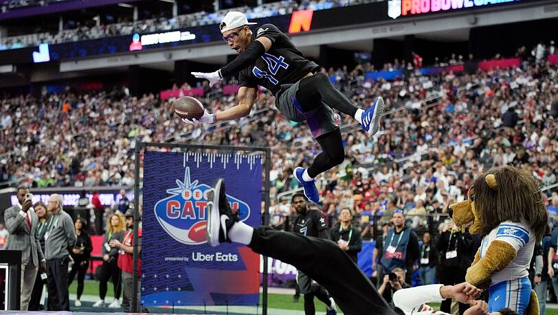 Detroits Wide Receiver Amon-Ra St. Brown (oben,l) fängt beim NFL-Pro-Bowl spektakulär einen Ball.