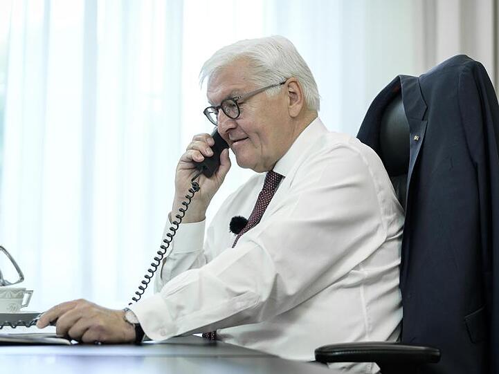 Bundespräsident Frank-Walter Steinmeier telefoniert an seinem Schreibtisch mit der Bewohnerin eines Altenheims in Bremen.