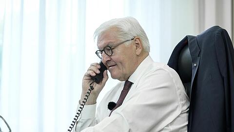 Bundespräsident Frank-Walter Steinmeier telefoniert an seinem Schreibtisch mit der Bewohnerin eines Altenheims in Bremen.