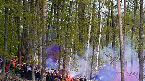 Aues Fans zünden in einem Waldstück neben dem Stadion Bengalos.