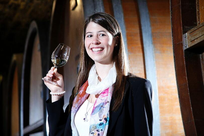 Die designierte fraenkische Weinkoenigin 2012/2013, Melanie Dietrich, posiert in Wuerzburg im Keller des Weinguts Buergerspital zum Heiligen Geist mit einem Glas Wein zwischen Faessern