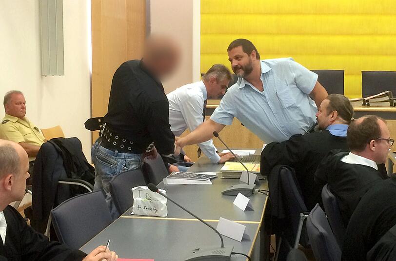 Der Angeklagte Sascha Roßmüller (r.), Vorstandsmitglied der bayerischen NPD, begrüßt im Landgericht Regensburg einen weiteren Angeklagten.