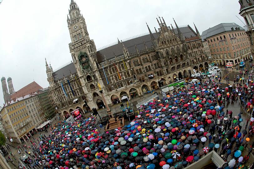 Das lange Warten auf die Pokalhelden. Es regnet und regnet und dennoch warten schon tausende Bayern-Fans auf das Eintreffen der Bayern-Stars. Die Bilder vom Marienplatz