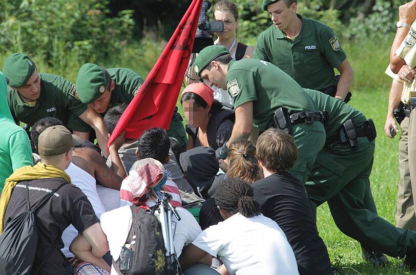 Einsatzkräfte versuchen bei Druisheim, einzelne Flüchtlinge aus dem Pulk herauszuziehen, um ihre Identitäten festzustellen.