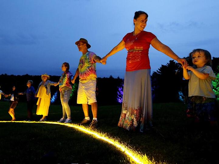 Woodstock-Nostalgie: Hand in Hand im Kreis um ein Friedenssymbol.