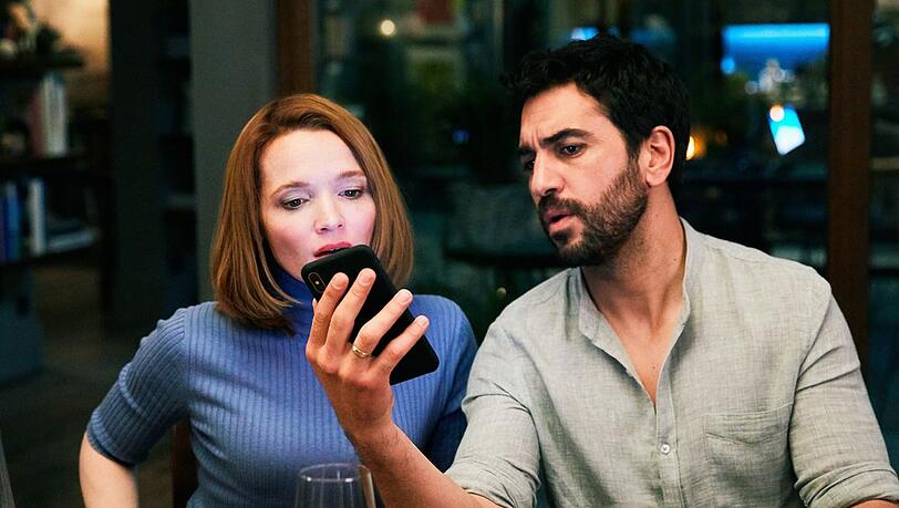 "Das perfekte Geheimnis": Familienvater Leo (Elyas M'Barek) liest Nachrichten vom Handy seiner Frau Carlotta (Karoline Herfurth).