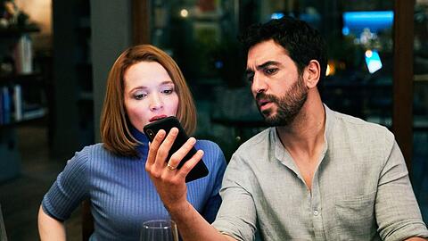 "Das perfekte Geheimnis": Familienvater Leo (Elyas M'Barek) liest Nachrichten vom Handy seiner Frau Carlotta (Karoline Herfurth).