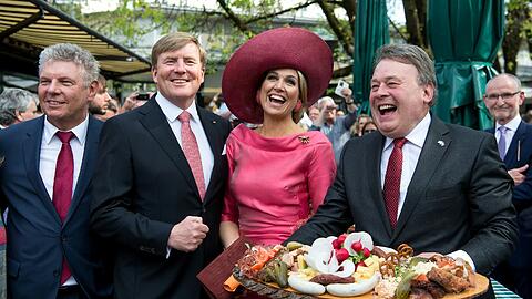 Auf dem Viktualienmarkt haben der bayerische Landwirtschaftsminister Helmut Brunner (r.) und Münchens OB Dieter Reiter (l.) dem holländischen Königspaar eine Brotzeit überreicht.