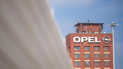 Der historische Opelturm steht hinter einem Zaun auf dem Werksgelände von Opel.