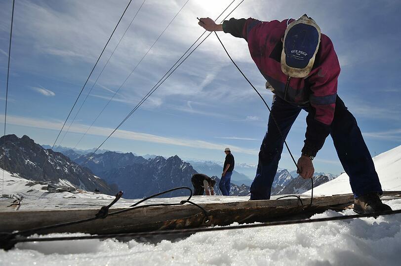 Rettungsaktion für die Zugspitze: Arbeiter decken den Gletscher mit Planen ab.