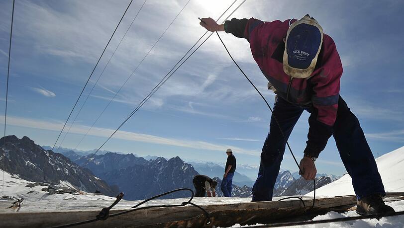 Rettungsaktion für die Zugspitze: Arbeiter decken den Gletscher mit Planen ab. Rettungsaktion für die Zugspitze: Arbeiter decken den Gletscher mit Planen ab.