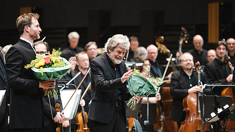 Der Dirigent Christian Schumann mit Reinhold Messner und den Stuttgarter Philharmonikern in der Isarphilharmonie.