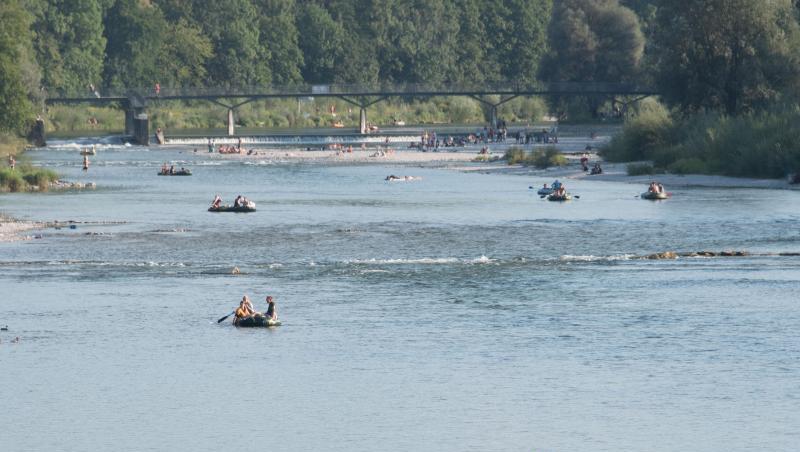 Schlauchbootfahrer und Badende auf der Isar am Flaucher. Foto: picture alliance / dpa/Archivbild