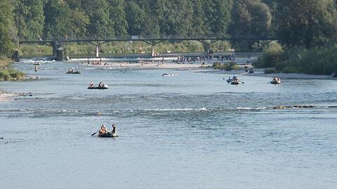 Schlauchbootfahrer und Badende auf der Isar am Flaucher. Foto: picture alliance / dpa/Archivbild
