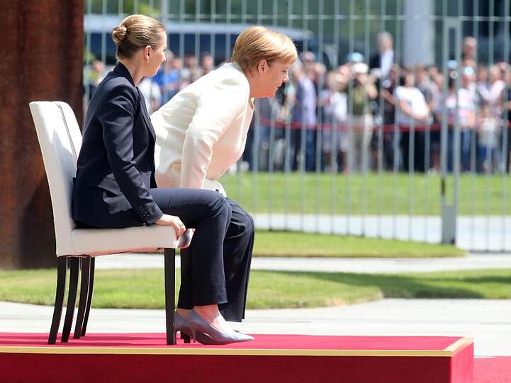 In sitzender Position verfolgen Angela Merkel und die dänische Ministerpräsidentin Mette Frederiksen das Abspielen der Nationalhymnen.