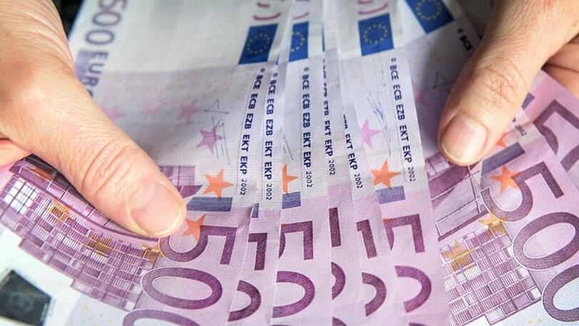 Eine Frau zählt 500-Euro-Geldscheine.
