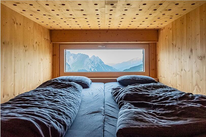 Zwei Betten in der Falkenhütte mit Berg-Ausblick. Zwei Betten in der Falkenhütte mit Berg-Ausblick.