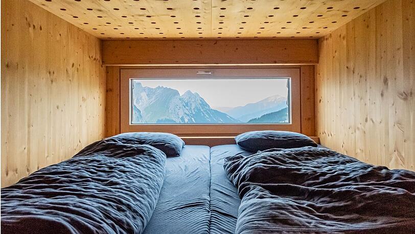 Zwei Betten in der Falkenhütte mit Berg-Ausblick. Zwei Betten in der Falkenhütte mit Berg-Ausblick.