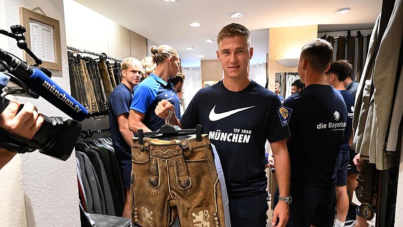 Der Spieler des TSV 1860, Martin Kobylanski, hält eine Lederhose hoch.