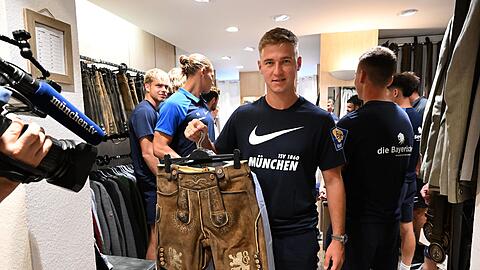 Der Spieler des TSV 1860, Martin Kobylanski, hält eine Lederhose hoch.