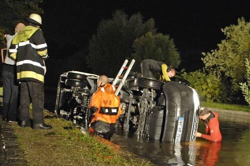 Feuerwehrmänner sichern den Kleinlaster im Kanal