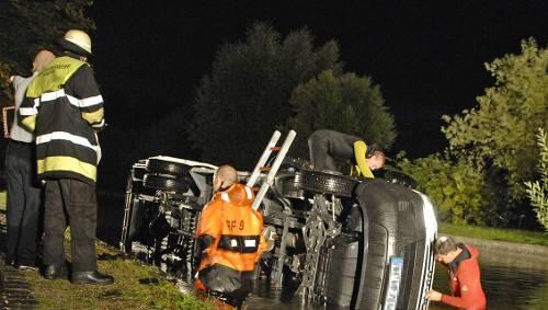 Feuerwehrmänner sichern den Kleinlaster im Kanal Feuerwehrmänner sichern den Kleinlaster im Kanal