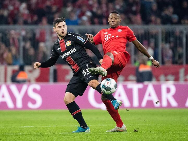 Kevin Volland von Leverkusen (l) und David Alaba vom FC Bayern München kämpfen um den Ball. Foto: Matthias Balk/dpa