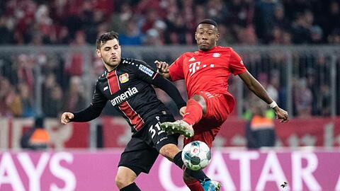 Kevin Volland von Leverkusen (l) und David Alaba vom FC Bayern München kämpfen um den Ball. Foto: Matthias Balk/dpa