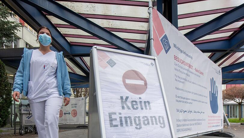 Eine Pflegerin geht aus dem Universitätsklinikum Augsburg. In dem Krankenhaus werden vor allem Corona-Patienten behandelt.
