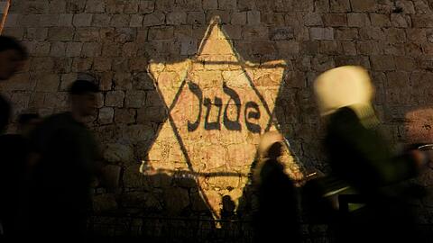 Ein gelber Davidstern mit der Aufschrift "Jude", ähnlich dem, den Juden in Nazi-Deutschland tragen mussten, wird am Abend des jährlichen Holocaust-Gedenktages Yom HaShoah auf die Mauern der Jerusalemer Altstadt projiziert.