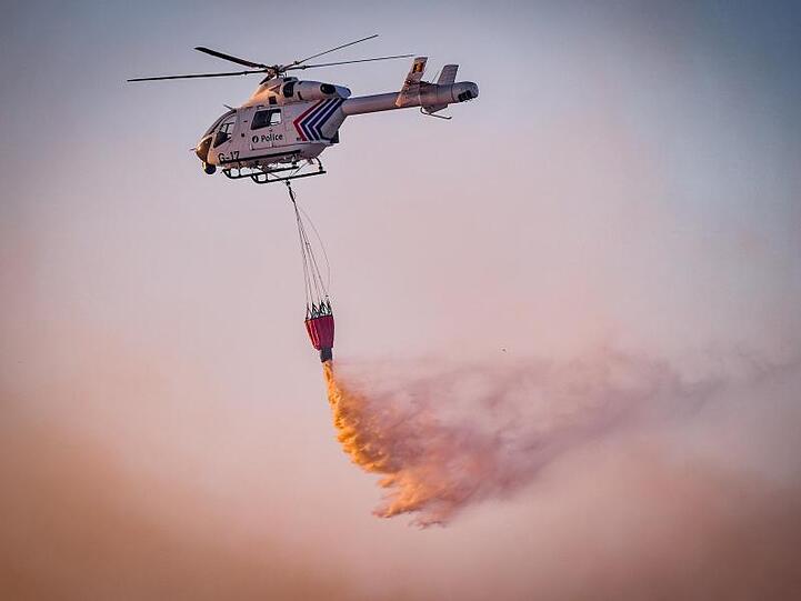 Mit Hilfe eines Hubschraubers wird aus der Luft versucht, das Feuer in dem Naturschutzgebiet "De Liereman" zu löschen.