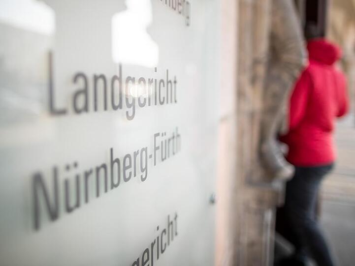 Ein Schild mit der Aufschrift "Landgericht Nürnber-Fürth". Foto: Daniel Karmann/dpa/Archivbild