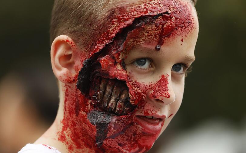 04.11.2017: "The Walking Dead" lässt grüßen... Dieser Junge ist mit seinem ultrarealistischen Horror-Makeup einer der Stars am Zombie Walk im Prince Alfred Park in Sydney (Australien).