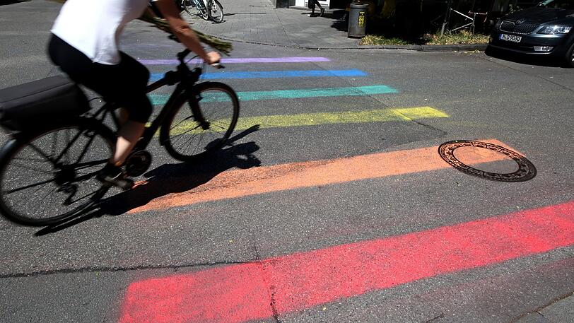 Fußgänger gehen am Holzplatz zur Prideweek über einen Regenbogen statt einen Zebrastreifen.