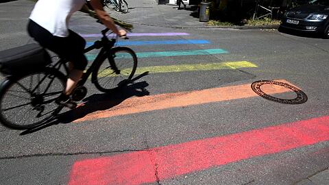 Fußgänger gehen am Holzplatz zur Prideweek über einen Regenbogen statt einen Zebrastreifen.