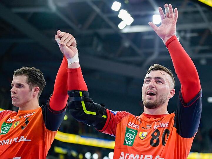 Jannik Kohlbacher (r) und Vladan Lipovina von den Rhein-Neckar Löwen feiern den Sieg gegen Nantes.