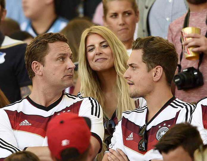 Zwischen zwei Deutschland-Fans steht Lisa, die Freundin von Robert Weidenfeller