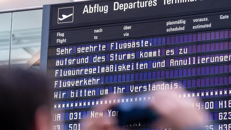 Ein Reisender fotografiert am Münchner Flughafen eine Anzeigetafel. Foto: Matthias Balk/dpa