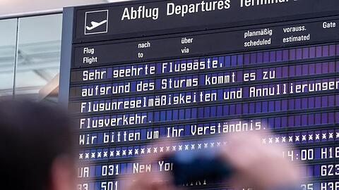 Ein Reisender fotografiert am Münchner Flughafen eine Anzeigetafel. Foto: Matthias Balk/dpa