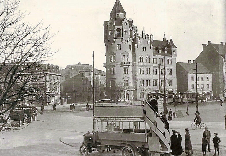 Früheres Wahrzeichen des Rotkreuzplatzes: Der Turm der alten Winthir-Apotheke an der Ecke Leonrodstraße/Nymphenburger Straße stand bis 1944. Im Vordergrund parkt ein Doppeldeckerbus.