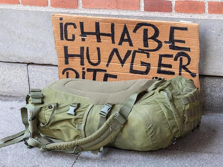 Ein Pappschild mit der Aufschrift "Ich habe Hunger" steht an einer Hausecke in der Münchner Innenstadt.
