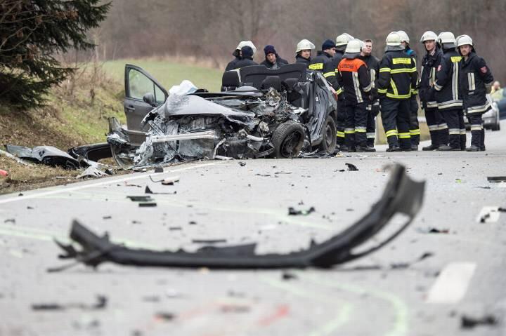 Die Straße ist mit Bruchstücken übersät. Das niedrige Gebilde vor den Rettungskräften ist das beteiligte Auto.