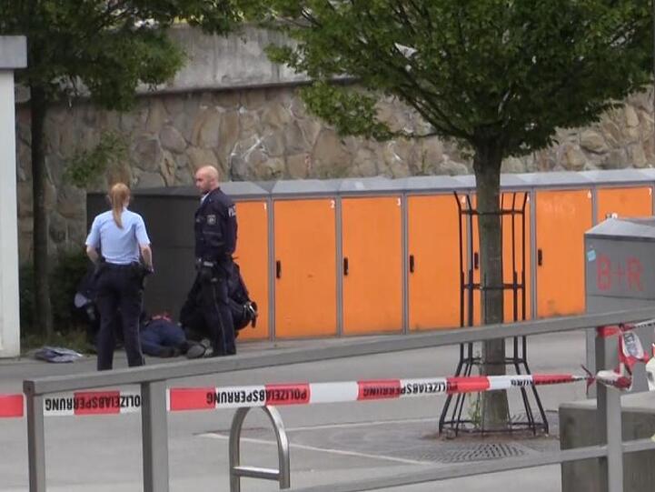 Polizisten am Stadtbahnhof in Iserlohn neben dem am Boden liegenden Tatverdächtigen.